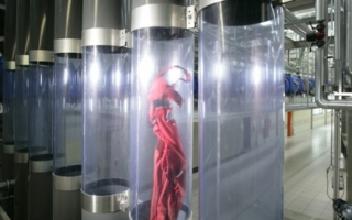 In den Röhren wird die getragene Berufs- und Schutzkleidung nach dem Prinzip der Rohrpost weitertransportiert Photos: Mewa