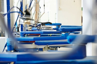 Auf Industrie-Bügelanlagen erhält die Kleidung das perfekte Finish. Photo: Packservice
